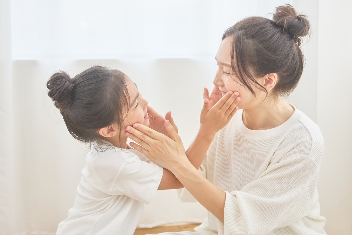 顔に触れ合って笑うママと娘